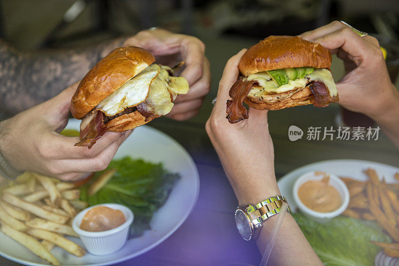 两个人拿着汉堡/食物摄影概念(点击查看更多)